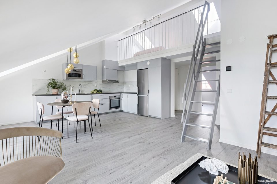 Kök och matplats med entresolplan ovanför och trappstege upp.